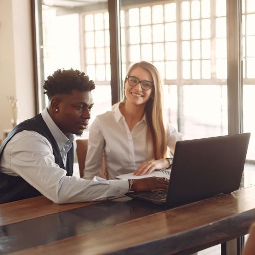 Handsome black man in a blue shirt. Businessman working in a cafe. Woman with her business partner.